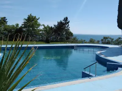 a large swimming pool with blue water at The Blue Studio - In a complex next to the beach by Flаt Manаger in Pomorie