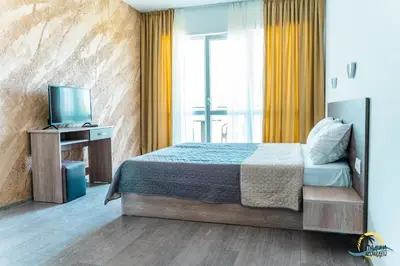 a bedroom with a bed and a television in it at Gradina Holiday in Sozopol