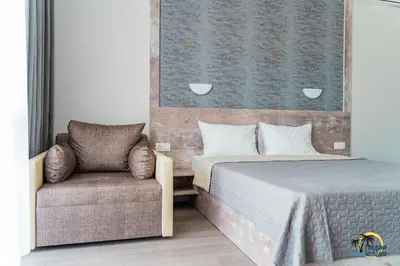 a bedroom with a bed and a chair at Gradina Holiday in Sozopol
