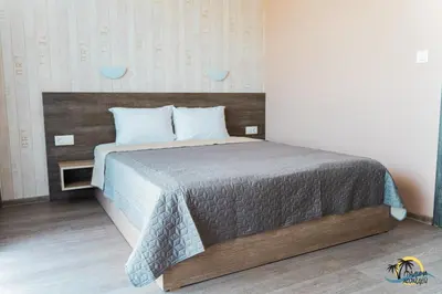 a bedroom with a large bed with a wooden headboard at Gradina Holiday in Sozopol
