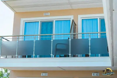 a balcony of a house with blue curtains at Gradina Holiday in Sozopol