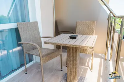 a wooden table and two chairs on a balcony at Gradina Holiday in Sozopol