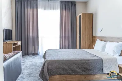 a hotel room with a bed and a television at Gradina Holiday in Sozopol