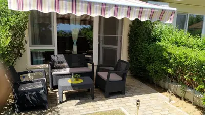 a patio with chairs and a table and an umbrella at Byala-apartment-valmira in Byala