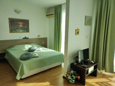 a bedroom with a bed with two pillows and a television at Прекрасен апартамент с изглед към морето Сарафово 1 in Burgas City