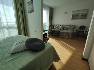 a bedroom with a bed with a pillow on it at Прекрасен апартамент с изглед към морето Сарафово 1 in Burgas City