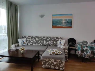 a living room with a couch and a table at Прекрасен апартамент с изглед към морето Сарафово 1 in Burgas City