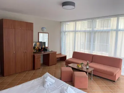 a living room with a couch and a tv at Hotel ECO Palace in Primorsko