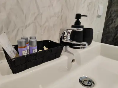 a basket sitting on a bathroom sink with a faucet at студио Водолей in Obzor