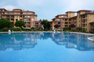 a large pool of blue water in front of buildings at Bright Studio with Parking & Pool in Sveti Vlas