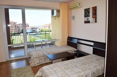 a room with two beds and a balcony at Bright Studio with Parking & Pool in Sveti Vlas