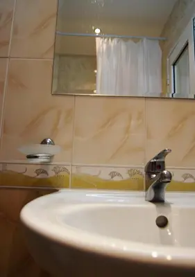 a bathroom sink with a faucet and a mirror at Bright Studio with Parking & Pool in Sveti Vlas