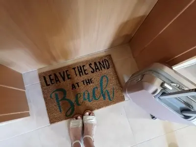 a sign that says leave the sand at the beach at Bright Studio with Parking & Pool in Sveti Vlas