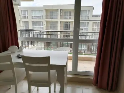 a room with a table and chairs and a large window at Cozy studio with Pool in Sunny Beach in Sunny Beach