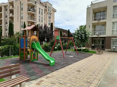 a playground with a slide in a courtyard at Cozy studio with Pool in Sunny Beach in Sunny Beach