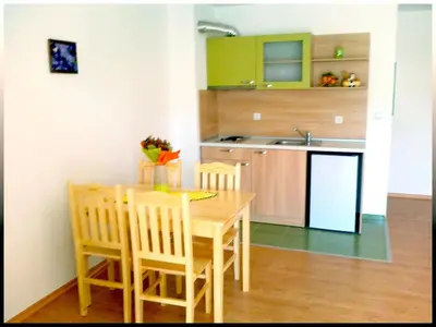 a small kitchen with a wooden table and chairs at Villa Denta in Nesebar
