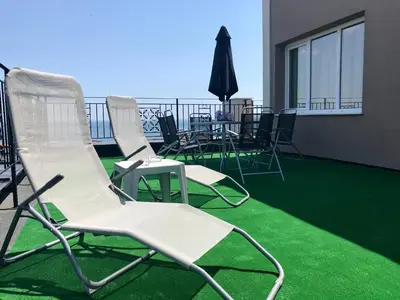 a group of chairs and tables on a balcony at Panorama beach Obzor in Obzor