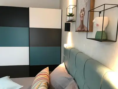 a bedroom with a bed with a blue and white headboard at Panorama beach Obzor in Obzor
