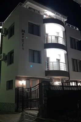 a large white building with a balcony at night at Villa Mareli in Tsarevo