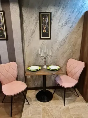 a table and two pink chairs in a room at MitProt luks studio Panorama Bay 2 ap.105 in Sveti Vlas
