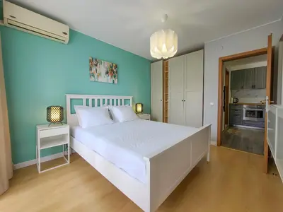 a bedroom with a white bed and a blue wall at Prestige Fort Aparthotel - Private apartment-BSR in Sveti Vlas