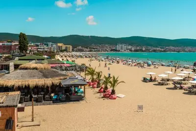 a beach with umbrellas and people on the sand at Sunny Fort Private Apartment in Sunny Beach