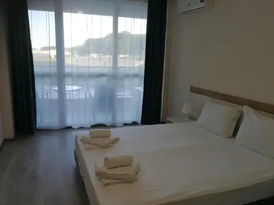 a bedroom with a large bed with two towels on it at Donchevi Apartments in Primorsko