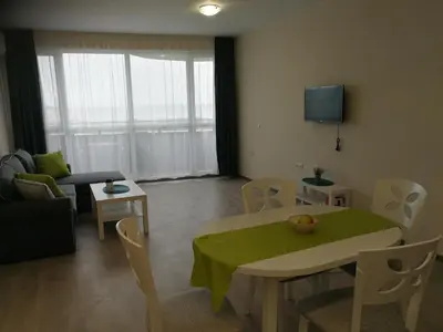 a living room with a table and a couch at Donchevi Apartments in Primorsko