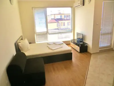 a room with a bed in front of a window at Apartment in Azalia 2 complex in Nesebar