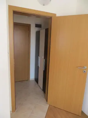 an empty hallway with two doors and a tile floor at Apartment in Azalia 2 complex in Nesebar
