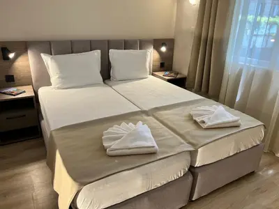 a large bed with two white towels on it at Lotos Apartments in Kiten