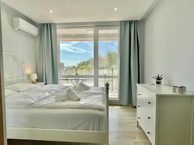 a bedroom with a bed and a large window at Paradiso Aparthotel - Private apartment-BSR-1 in Nesebar