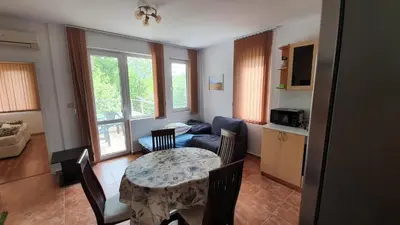 a living room with a table and a couch at Pomorie Beach Resort in Pomorie