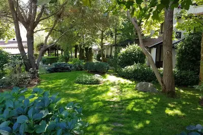 a yard with green grass and trees and a house at Apartment in the picturesque Oasis Resort & Spa in Lozenets