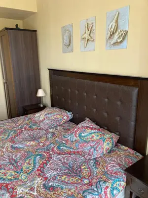 a bedroom with a bed with a comforter and pictures on the wall at Royal Beach Apartament Hotel in Sunny Beach