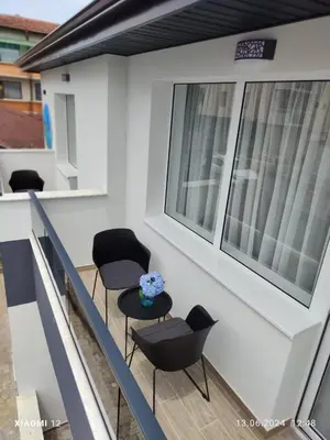 a balcony with two chairs and a table at Вила TIMeS in Kiten