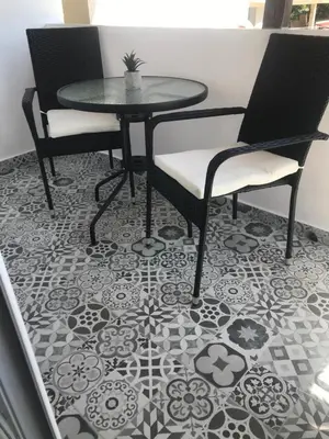 a table and two chairs on a tile floor at Вила TIMeS in Kiten