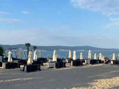 a group of tables and umbrellas on a beach at ANITA A3 Cosy Studio SUNNY BEACH in Sunny Beach