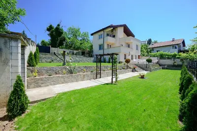 a house with a green lawn in front of it at Villa Baywatch in Galata