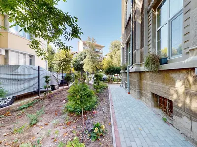 a sidewalk next to a building with a garden at Markoni 1 in Burgas City
