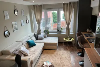 a living room with a couch and a window at Sunset Apartment in Pomorie