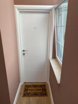 a small hallway with a door with a welcome mat at Markoni 2 in Burgas City