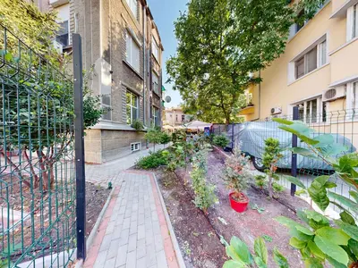 a garden in front of a building with a fence at Markoni 2 in Burgas City