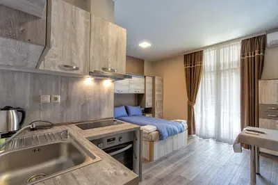 a kitchen with a sink and a bed in a room at BOLERO Suites in Varna City