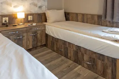 two beds in a room with wooden cabinets at BOLERO Suites in Varna City
