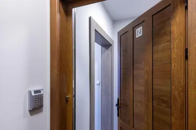 a hallway with a wooden door and a room with at BOLERO Suites in Varna City