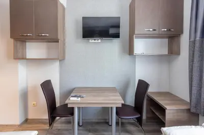 a dining room with a table and chairs and a tv at BOLERO Suites in Varna City