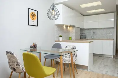 a kitchen with a glass table and chairs at Charisma apt - lux at top city center in Varna City
