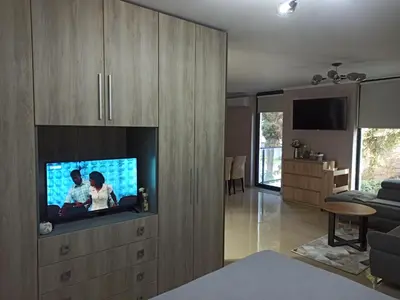 a living room with a tv in a wooden cabinet at AMARA-BOUTIQUE & DESIGN - Студио in Ravda
