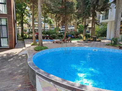 a large blue swimming pool in a courtyard with trees at AMARA-BOUTIQUE & DESIGN - Студио in Ravda